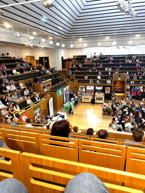 Clubwell in a large hall with attendees seated in rows