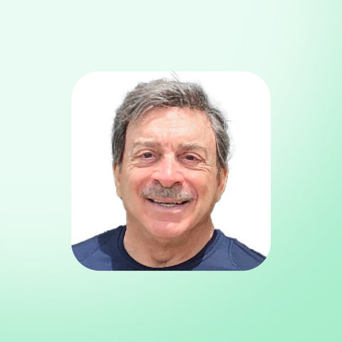 Dr Ben Bocchicchio with a mustache smiling on a light green background