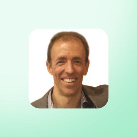 Dr James Goolnick smiling on a light green background