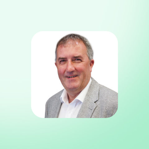 Dr Malcolm Kendrick in a gray blazer and white shirt on a light green background