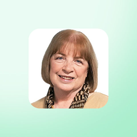 Dr Mary Newport with short brown hair and a patterned scarf on a light green background