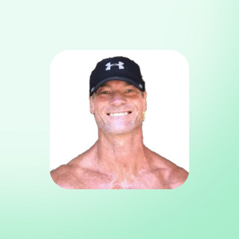 Dr Shawn Baker wearing a black cap with a logo on a light green background