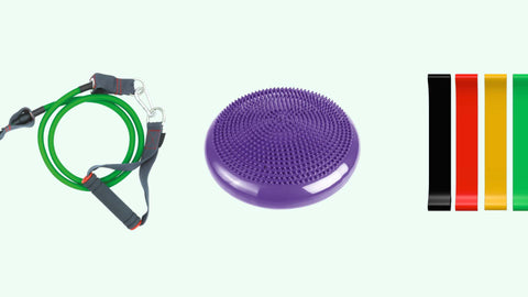 Purple balance disc, green resistance band and mixed colour resistance bands on a light green background
