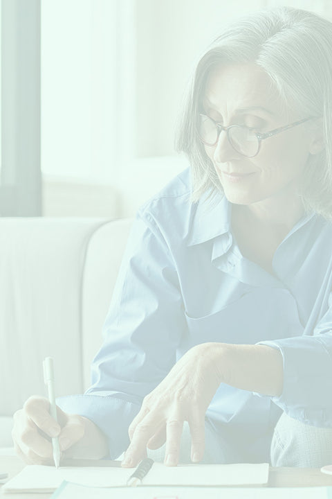 Person wearing glasses sitting on a couch with a blurred background
