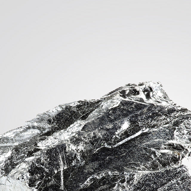 Close-up of a textured magnesium rock against a white background