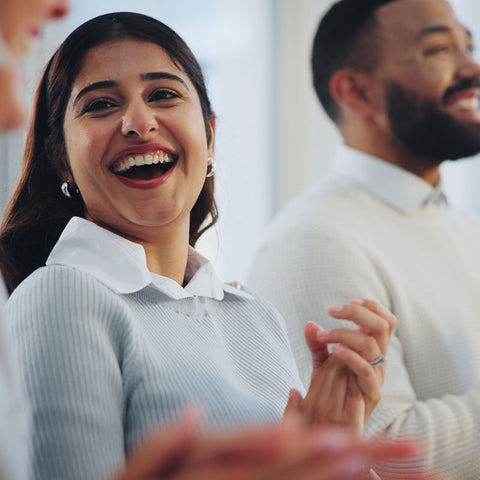 Woman laughing with a blurred background of people