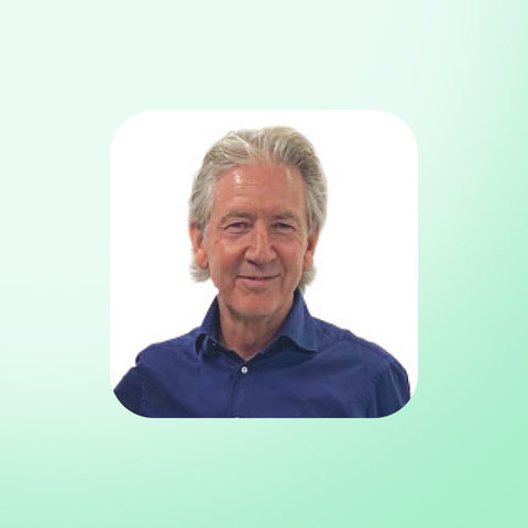 Patrick Holford wearing a blue shirt on a light green background