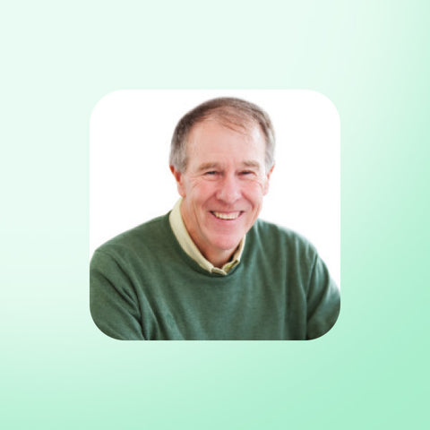 Professor Tim Noakes wearing a green sweater on a light green background