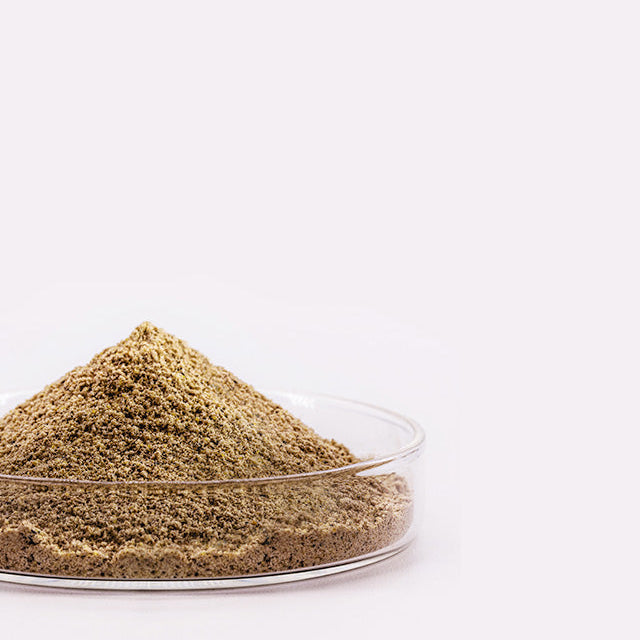 Powdered substance in a clear glass container on a white background